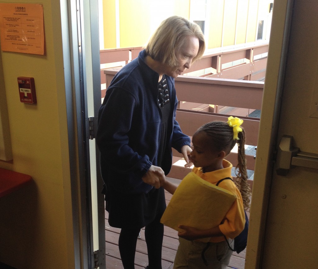 Lagniappe's principal, Kendall Petri, welcomes a student to school after checking to make sure she doesn't have an IEP.